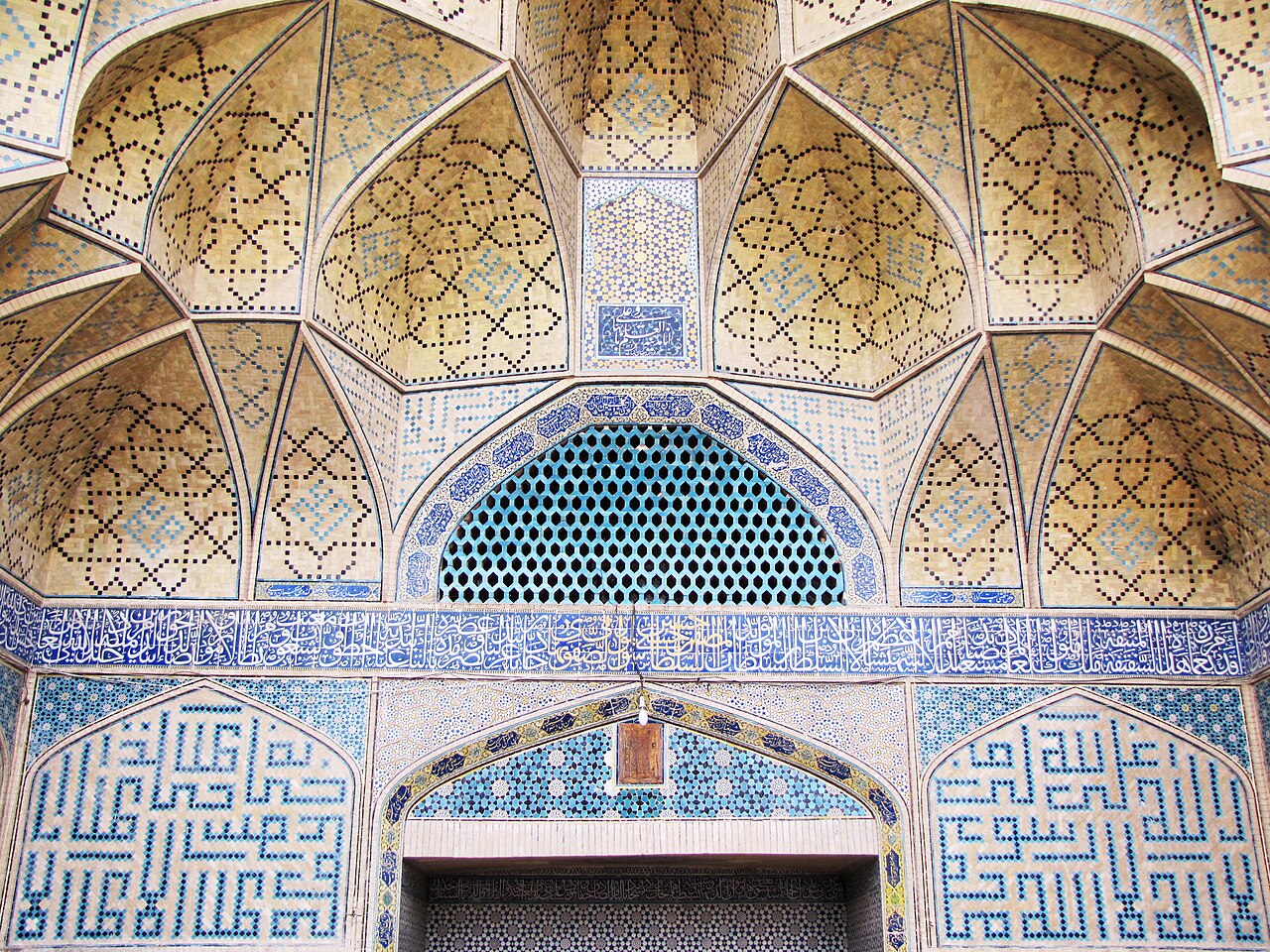 Turquoise and cobalt muqarnas tilework beneath the western iwan of the Jameh Mosque of Isfahan